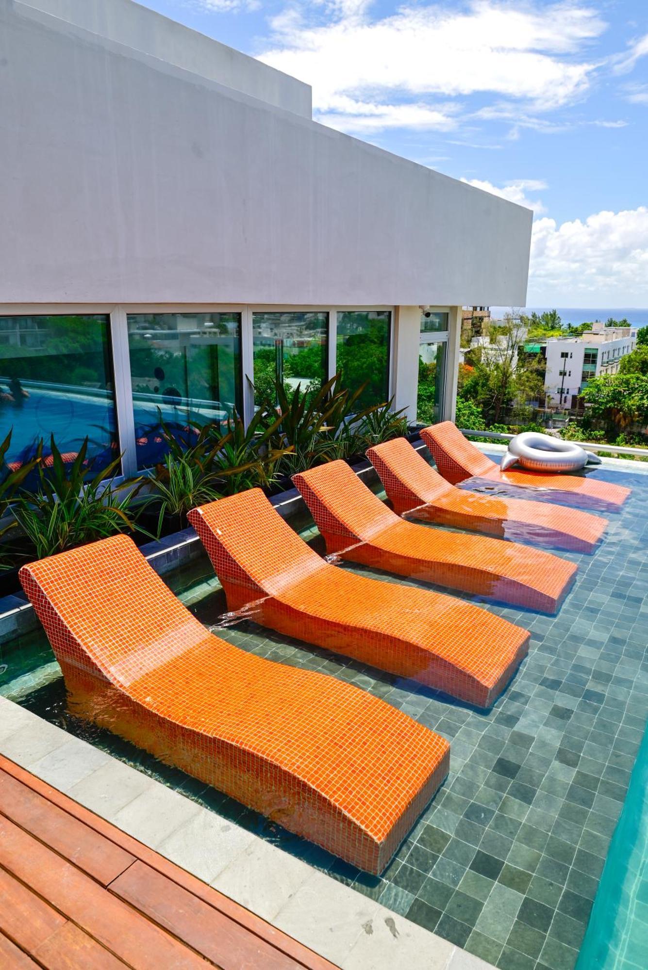 Готель Aloft Плайя-дель-Кармен Екстер'єр фото Sunbathing chairs at a pool